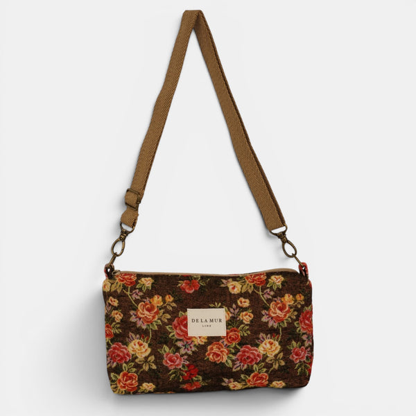 Bolso clutch Pepi, estampado en naranja, terracota, gris, detalle del material y el acabado — De La Mur