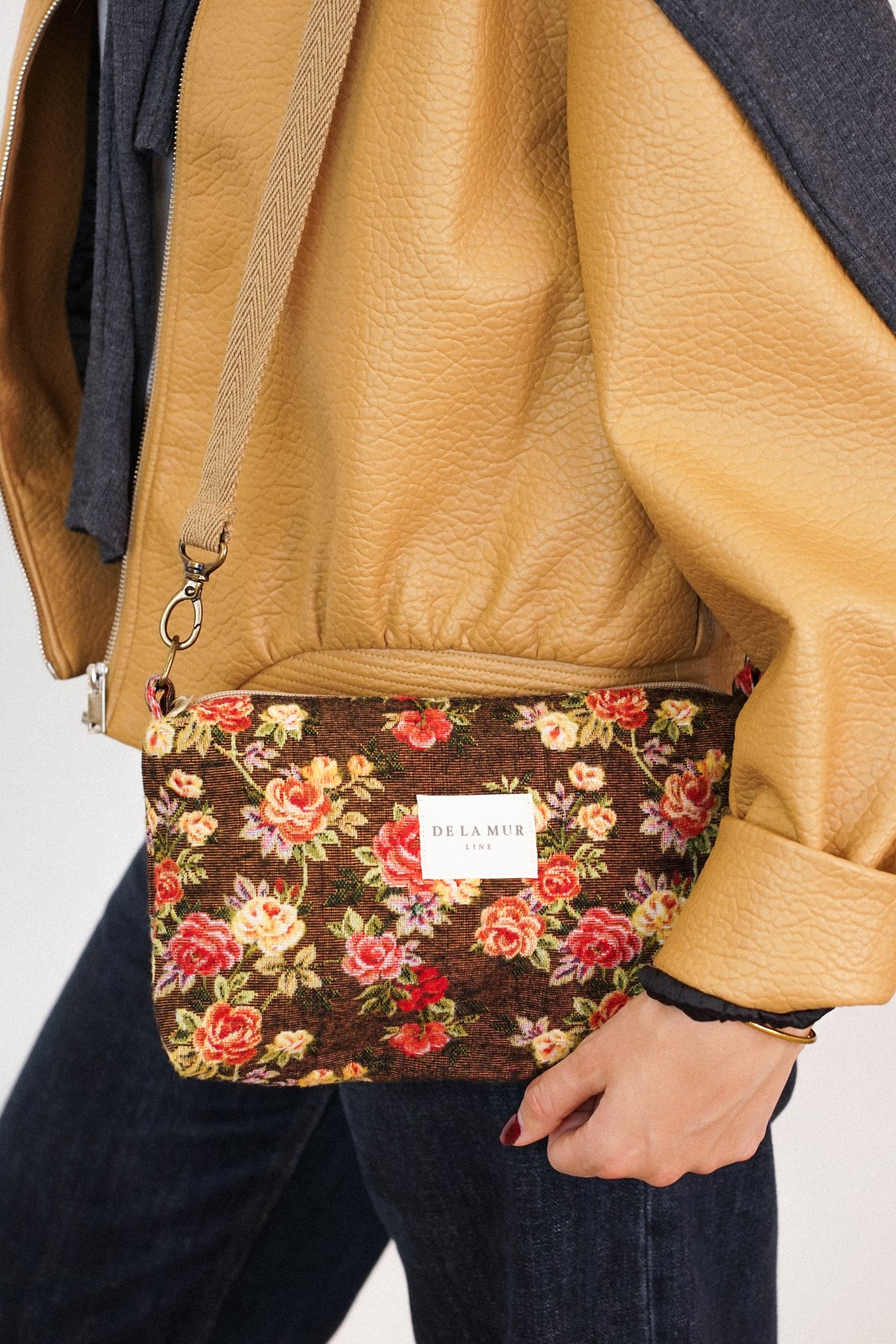 Bolso clutch Pepi, estampado en naranja, terracota, gris, vista en uso — De La Mur
