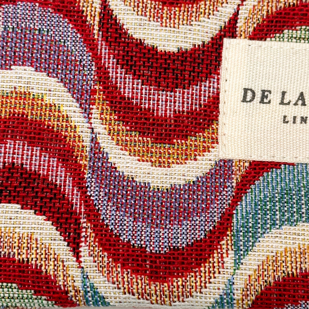Monedero Queen, estampado en rojo, beige, terracota, detalle del estampado y el material — De La Mur