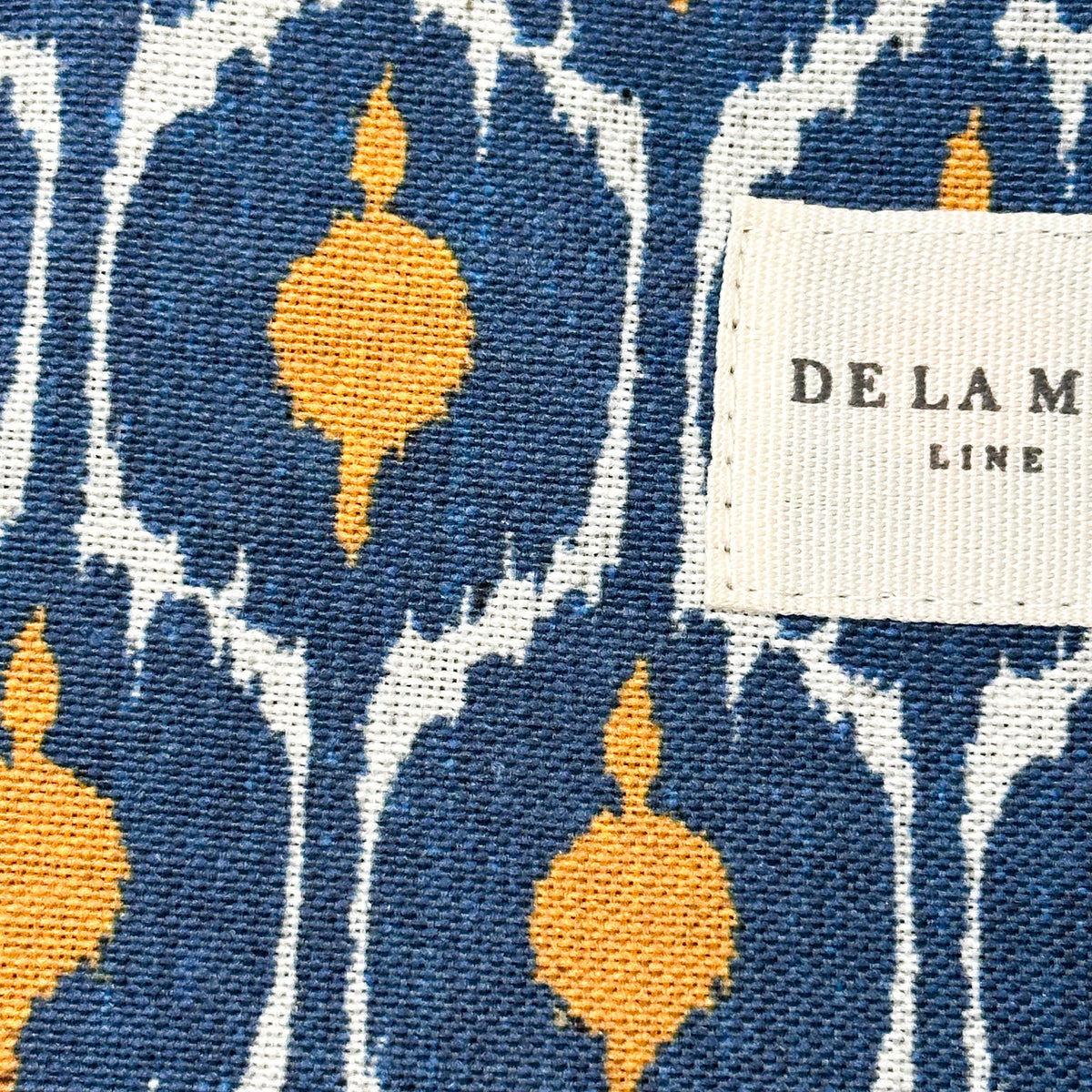 Monedero Brad, estampado en azul, naranja, gris, detalle del material y el acabado — De La Mur