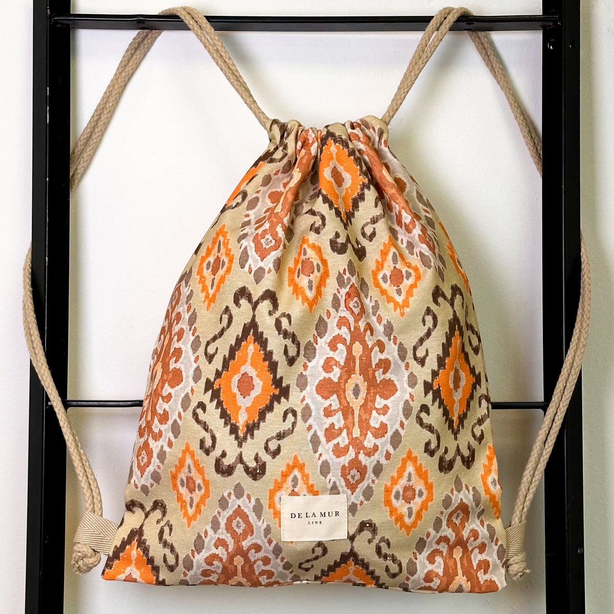 Monedero Ikat, estampado en beige, naranja, terracota, vista frontal — De La Mur