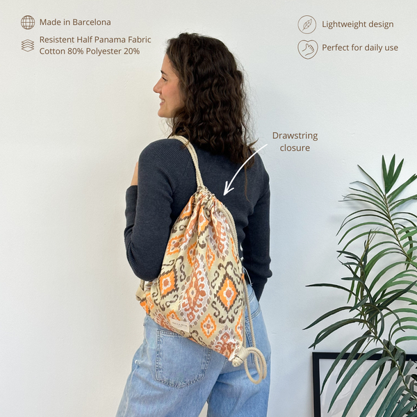 Monedero Ikat, estampado en beige, naranja, terracota, vista en uso — De La Mur