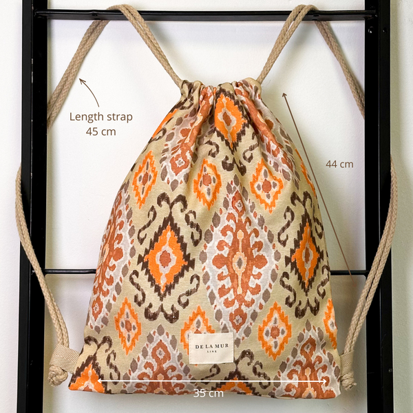Monedero Ikat, estampado en beige, naranja, terracota, vista con medidas — De La Mur