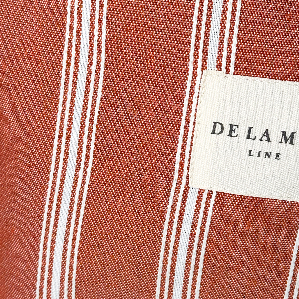 Neceser Mineo, estampado en rojo, beige, blanco, detalle del material y el acabado — De La Mur