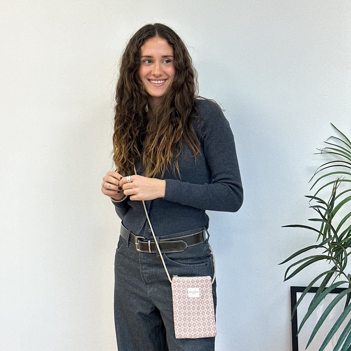 Bolsito porta móvil Gale, estampado en beige, rojo, negro, vista en uso — De La Mur