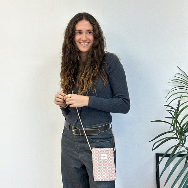 Bolsito porta móvil Gale, estampado en beige, rojo, negro, vista en uso — De La Mur