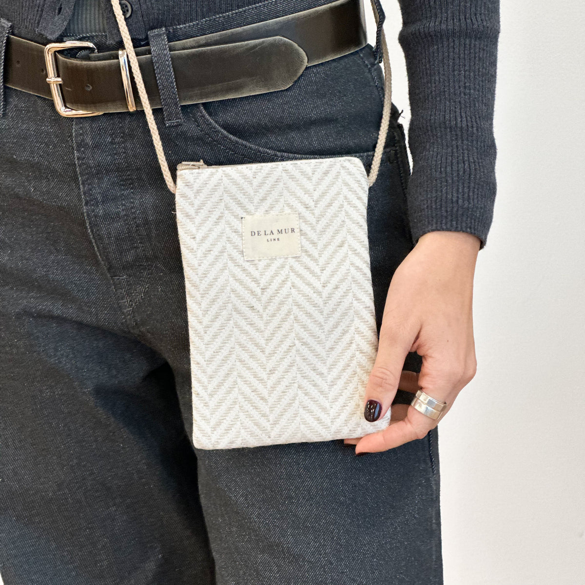 Bolsito porta móvil Rafi, estampado en beige, negro, gris, detalle del estampado y el material — De La Mur