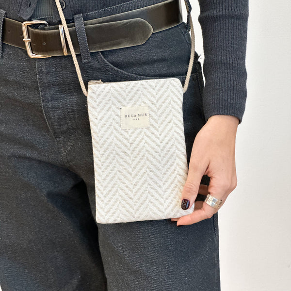 Bolsito porta móvil Rafi, estampado en beige, negro, gris, detalle del estampado y el material — De La Mur
