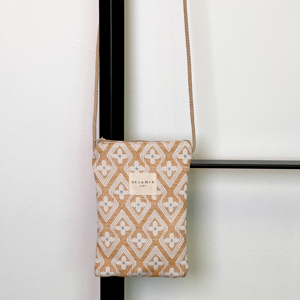 Bolsito porta móvil Raxo, estampado en beige, naranja, negro, vista frontal — De La Mur