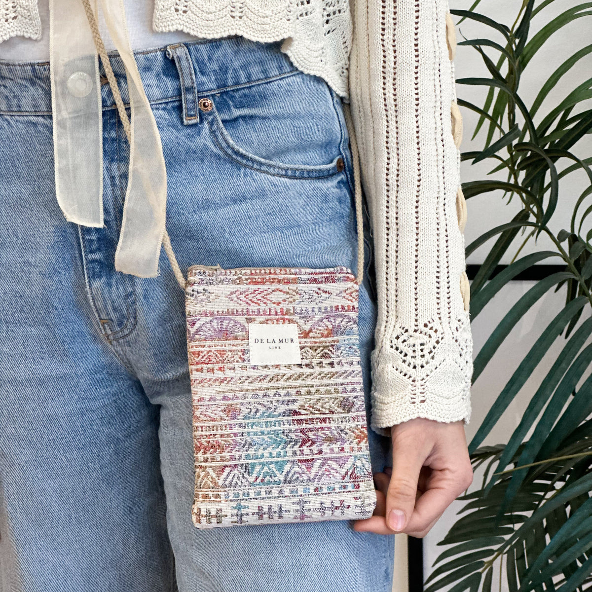Bolsito porta móvil Sira, estampado en beige, negro, marrón, detalle del estampado y el material — De La Mur