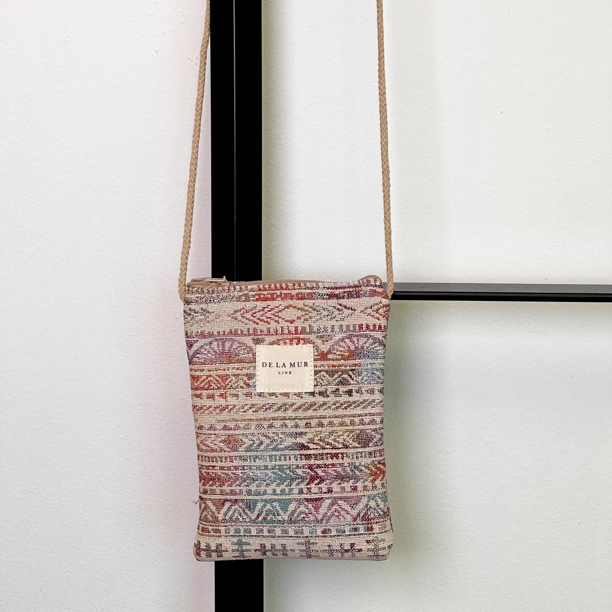 Bolsito porta móvil Sira, estampado en beige, negro, marrón, vista frontal — De La Mur
