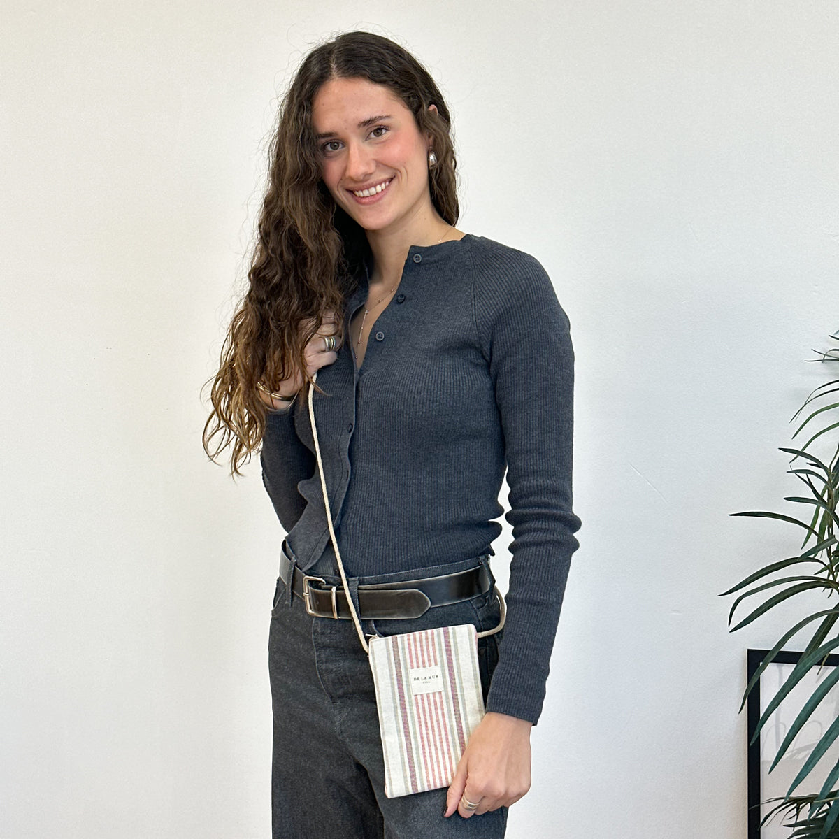 Bolsito porta móvil Tuli, estampado en beige, negro, rojo, vista en uso — De La Mur